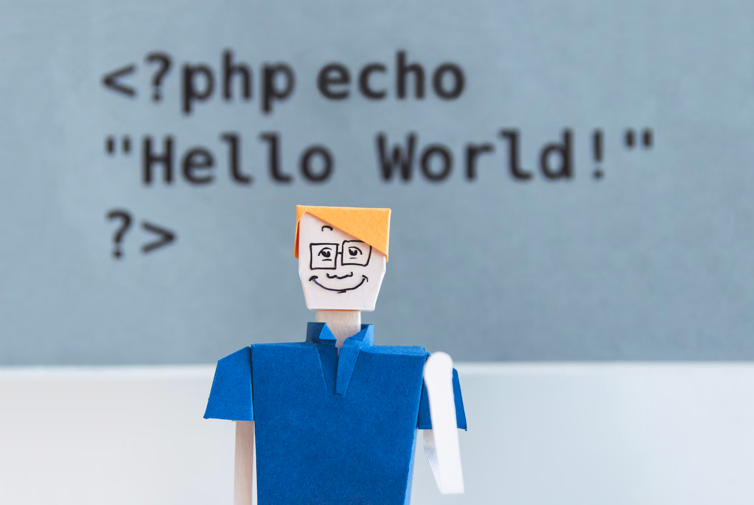 Paper figure in front of PHP Hello World code